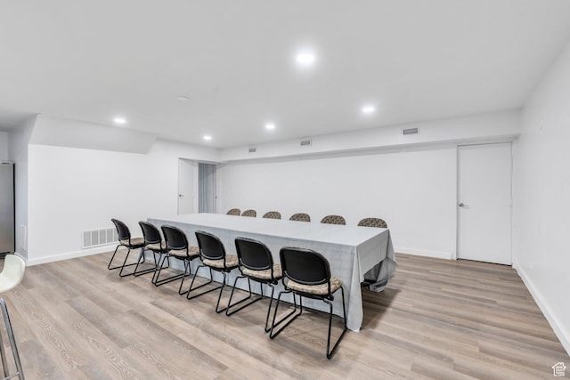 interior space with light wood-style flooring, visible vents, a breakfast bar area, and recessed lighting