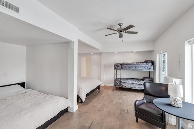 bedroom featuring visible vents, ceiling fan, baseboards, and wood finished floors