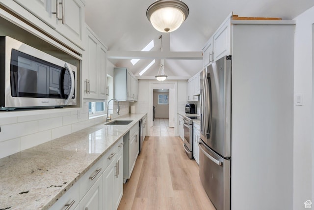 kitchen with white cabinetry, decorative backsplash, stainless steel appliances, and a sink