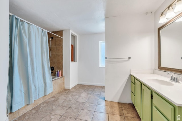 bathroom with tile patterned flooring, tiled shower / bath, baseboards, and vanity