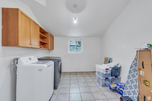 laundry area featuring light tile patterned floors, separate washer and dryer, and cabinet space