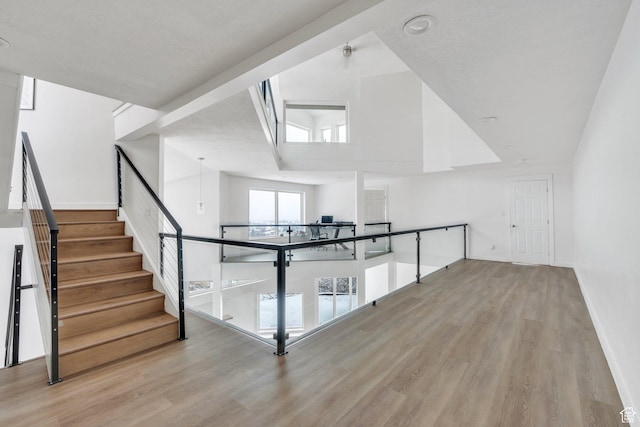bonus room featuring high vaulted ceiling, baseboards, and wood finished floors