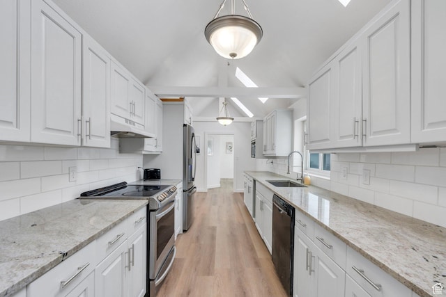 kitchen with vaulted ceiling with skylight, under cabinet range hood, stainless steel appliances, a sink, and white cabinetry