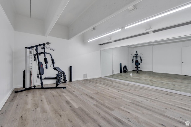 exercise area with visible vents and wood finished floors