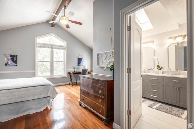 1494 W Meadow Loop Rd, Park City, UT 84098 - bedroom with a ceiling fan, lofted ceiling with skylight, a sink, light wood-type flooring, and ensuite bathroom