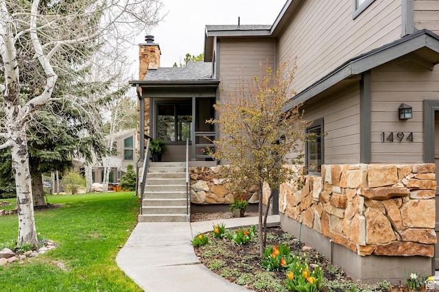 1494 W Meadow Loop Rd, Park City, UT 84098 - view of exterior entry with stone siding, roof with shingles, a chimney, and a lawn