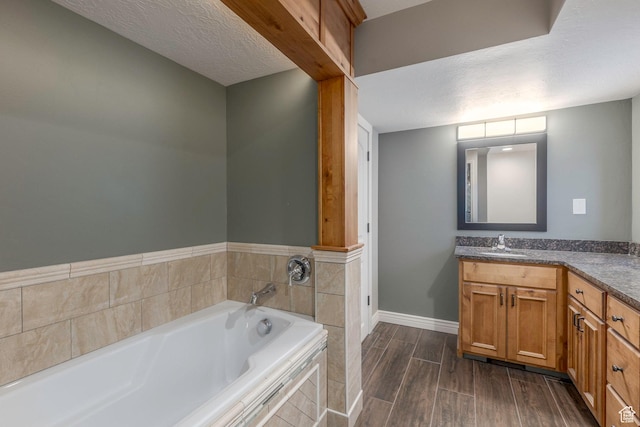 2008 N 3850 E, Eden, UT 84310 - bathroom featuring vanity, a garden tub, wood finished floors, baseboards, and a textured ceiling