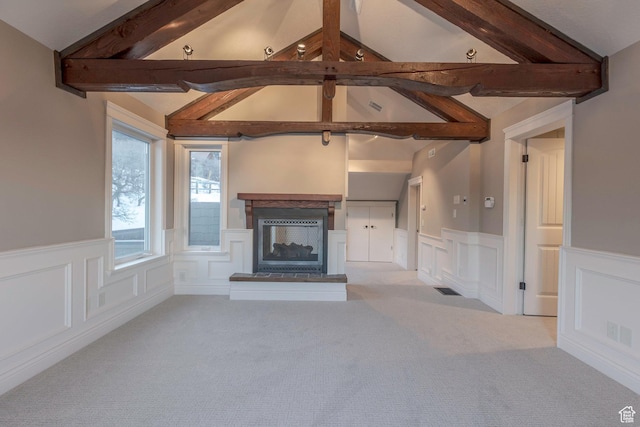 2008 N 3850 E, Eden, UT 84310 - unfurnished living room with carpet floors, a decorative wall, a wainscoted wall, lofted ceiling with beams, and a multi sided fireplace