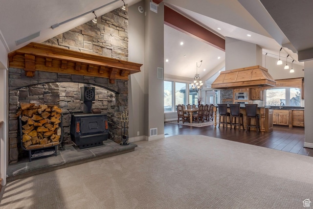 2008 N 3850 E, Eden, UT 84310 - living room with a wood stove, high vaulted ceiling, dark colored carpet, an inviting chandelier, and dark wood-type flooring