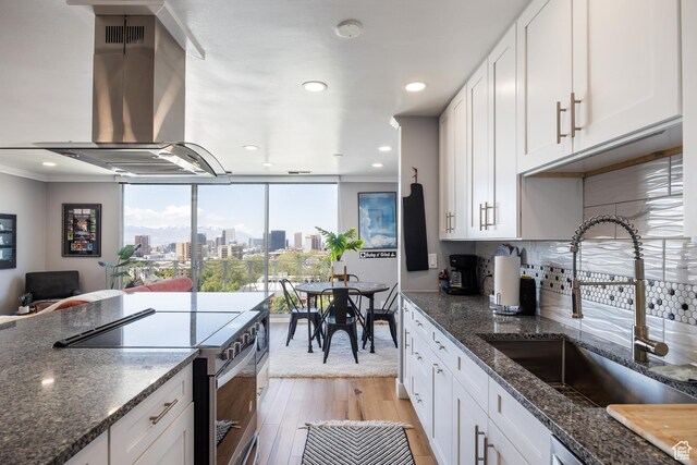 777 E S Temple S Unit 11F, Salt Lake City, UT 84102 - kitchen featuring stainless steel electric stove, a sink, island range hood, light wood-type flooring, and crown molding