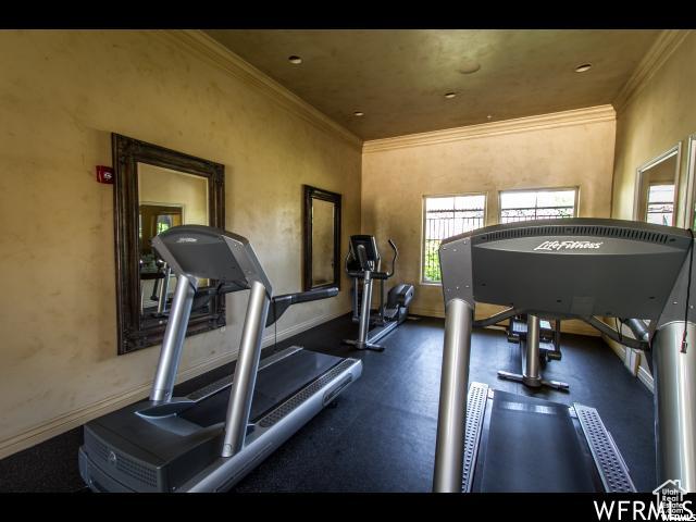 workout area with baseboards and ornamental molding