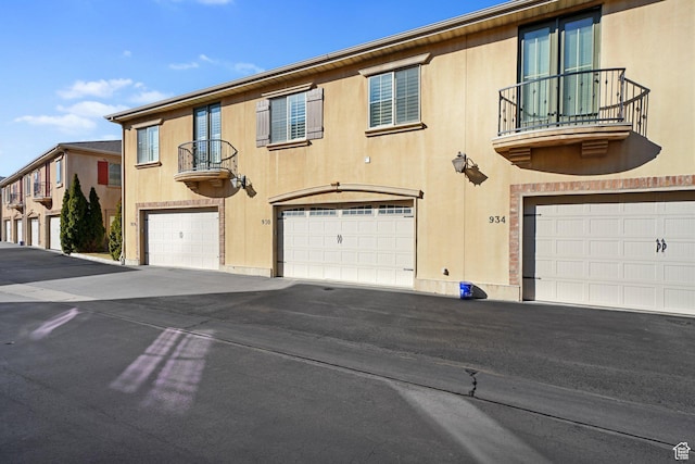 view of front of home featuring driveway, a balcony, and a garage