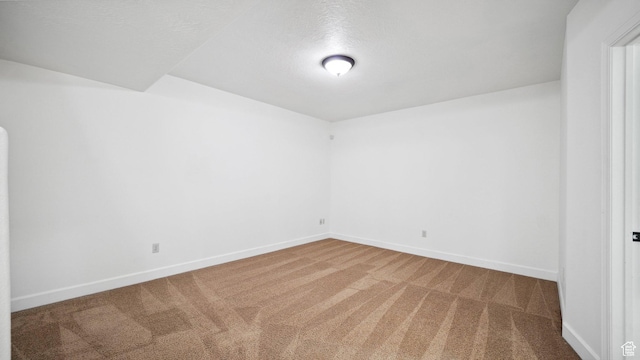 unfurnished room featuring carpet and baseboards