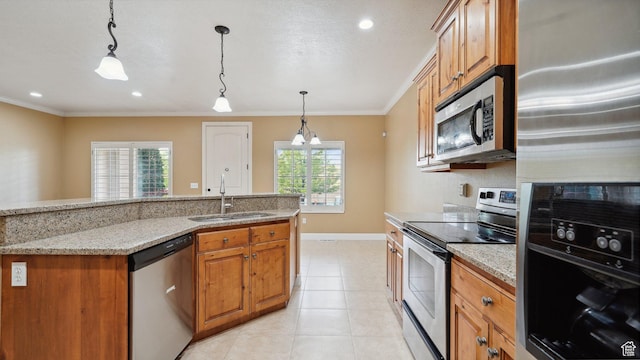 kitchen with stainless steel appliances, ornamental molding, brown cabinetry, and a sink