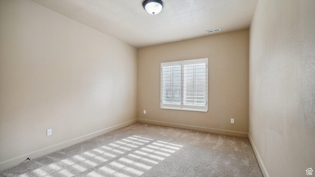 unfurnished room featuring visible vents, light colored carpet, and baseboards