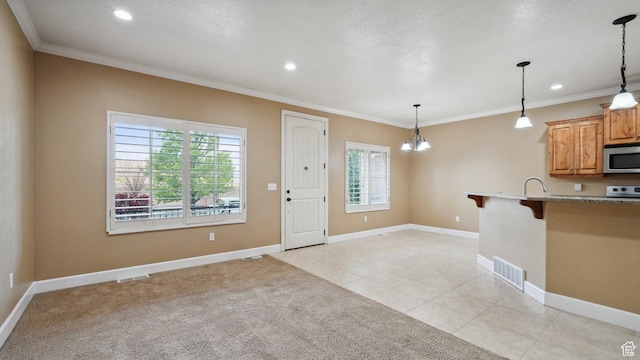kitchen with a breakfast bar area, stainless steel microwave, a healthy amount of sunlight, and visible vents