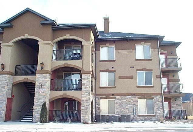 snow covered building featuring cooling unit
