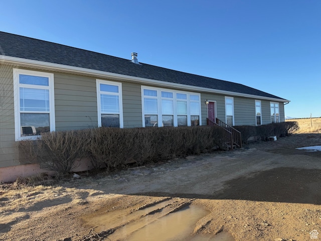 view of front facade featuring entry steps and roof with shingles