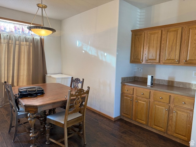 dining space featuring dark wood-style flooring and baseboards