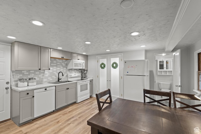 162 S 3 E, Preston, ID 83263 - kitchen with gray cabinets, a sink, a textured ceiling, white appliances, and light wood-style floors