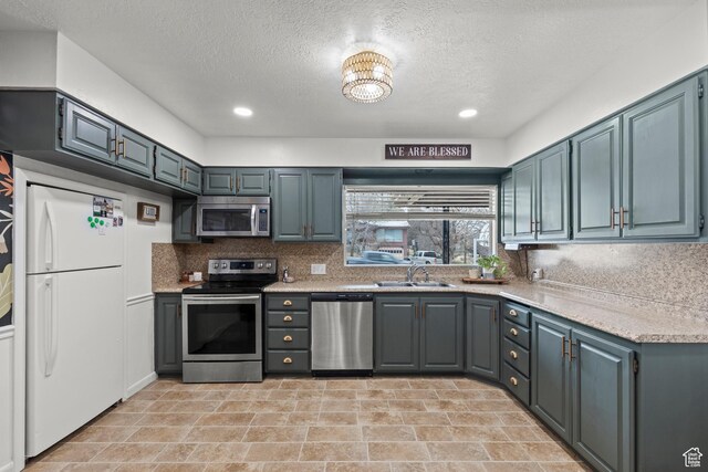 162 S 3 E, Preston, ID 83263 - kitchen featuring light countertops, backsplash, a sink, a textured ceiling, and stainless steel appliances