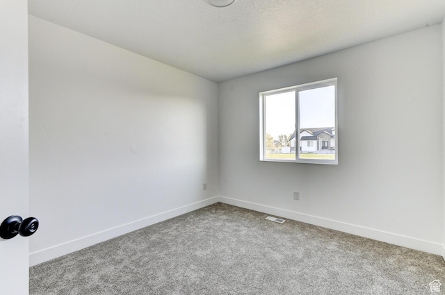carpeted empty room featuring visible vents and baseboards