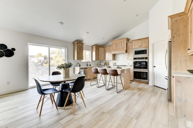 dining room with light wood-type flooring and lofted ceiling