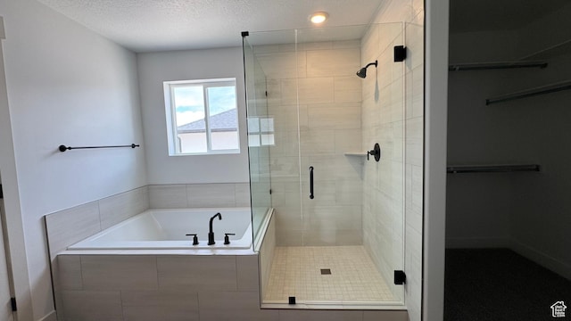 445 W 1910 N Unit 318, Tooele, UT 84074 - bathroom with a stall shower, a garden tub, a spacious closet, and a textured ceiling