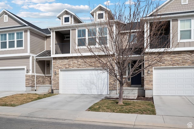 116 W Condor Rd N, Saratoga Springs, UT 84045 - view of property with a garage, concrete driveway, stone siding, and a balcony