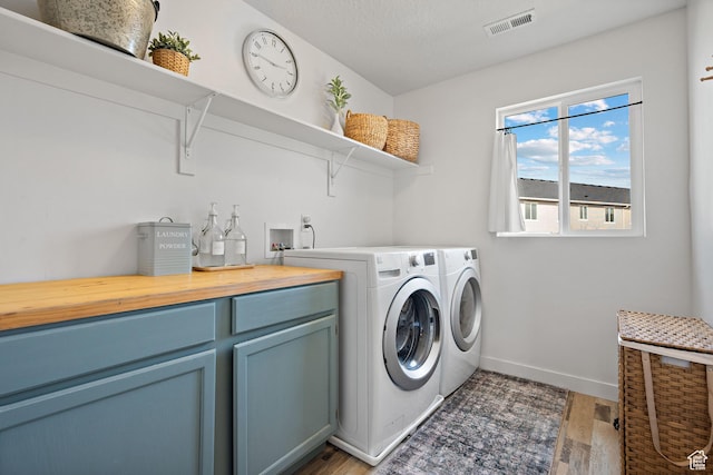 116 W Condor Rd N, Saratoga Springs, UT 84045 - laundry area with washing machine and dryer, visible vents, baseboards, light wood-style floors, and cabinet space