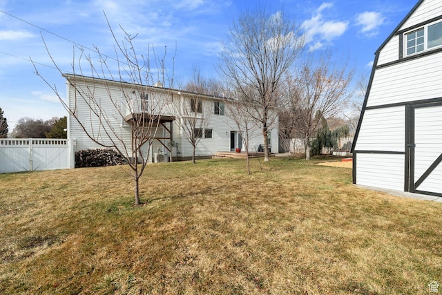 view of yard featuring a storage shed, fence, and an outbuilding
