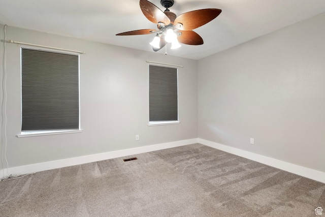 spare room with a ceiling fan, baseboards, visible vents, and carpet flooring