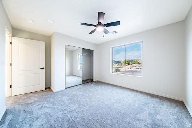 unfurnished bedroom featuring a closet, visible vents, carpet flooring, and multiple windows