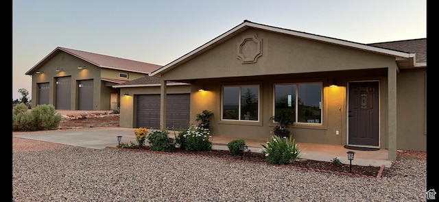 978 S Hamblin Dr, Kanab, UT 84741 - view of front of house featuring stucco siding, concrete driveway, and a garage