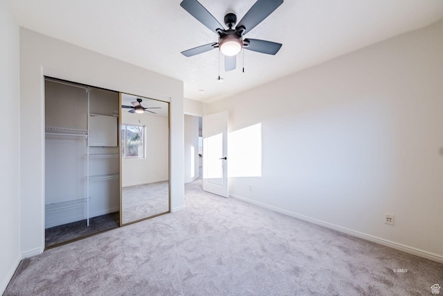 unfurnished bedroom with a ceiling fan, carpet, a closet, and baseboards