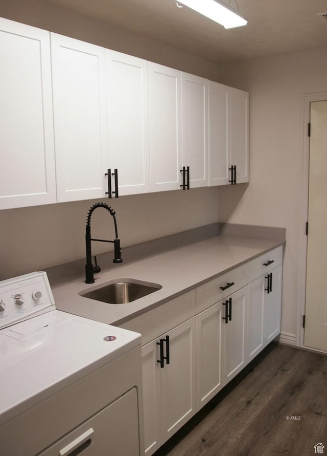 washroom with a sink, visible vents, cabinet space, washer / clothes dryer, and dark wood finished floors