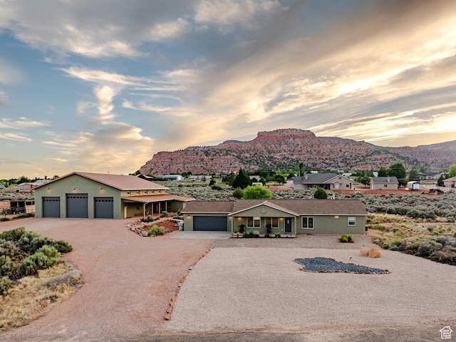 ranch-style home with a mountain view, driveway, and stucco siding