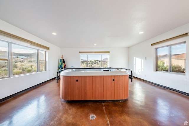 kitchen featuring finished concrete flooring, a kitchen island, a wealth of natural light, and recessed lighting