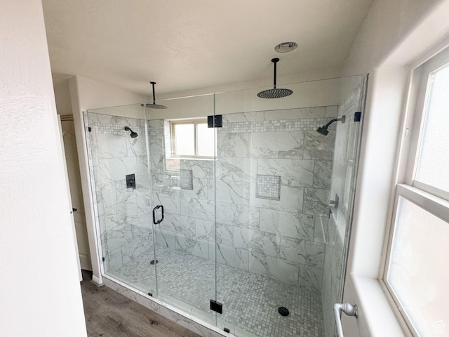 full bathroom with a stall shower and wood finished floors