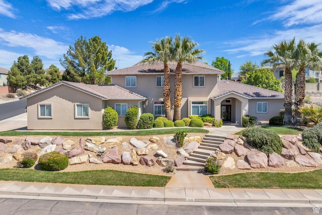 mediterranean / spanish-style house featuring stairway and stucco siding