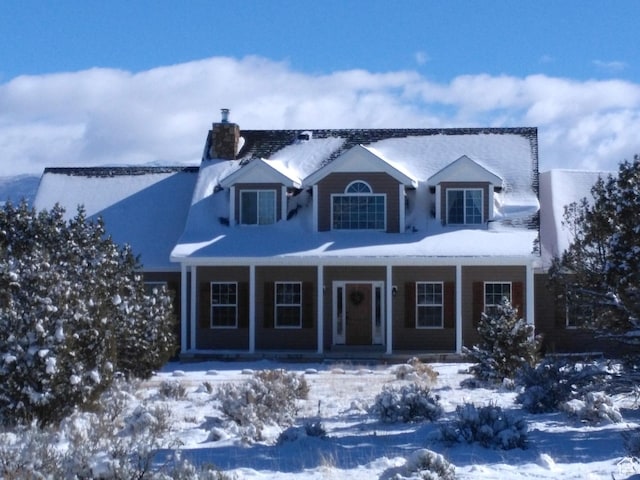 view of front of home featuring covered porch and a chimney