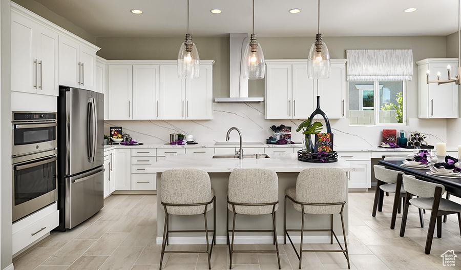 635 S 230 W Unit 5, Ivins, UT 84738 - kitchen featuring wall chimney exhaust hood, stainless steel appliances, light countertops, white cabinetry, and a sink