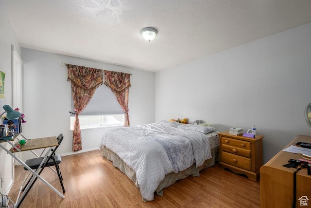 bedroom with light wood finished floors and baseboards