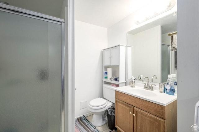 bathroom featuring toilet, a shower stall, and vanity