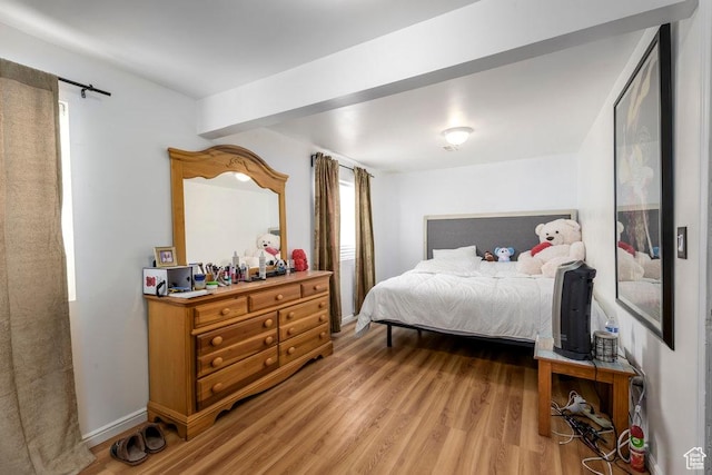 bedroom with light wood finished floors and baseboards