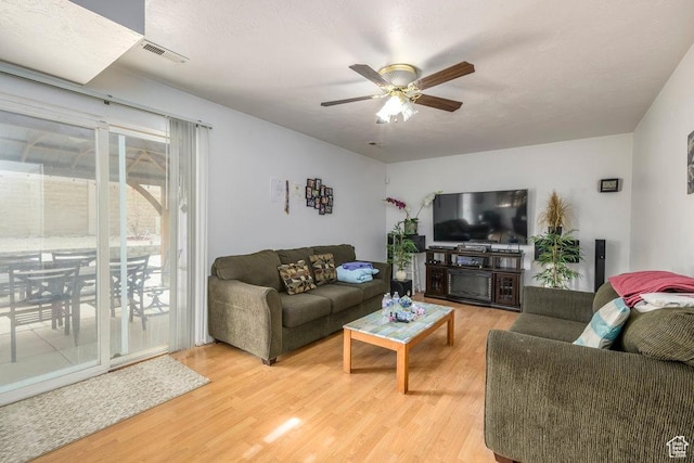 living area with a ceiling fan, visible vents, and light wood-style flooring