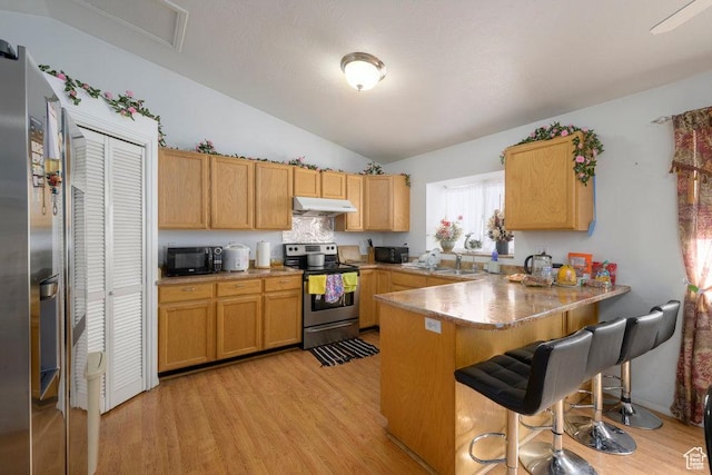 kitchen featuring electric range, a peninsula, black microwave, under cabinet range hood, and a kitchen bar