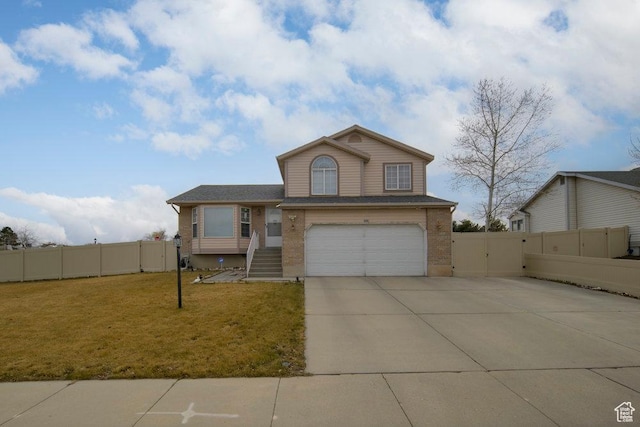 split level home featuring a gate, fence, concrete driveway, and a front yard