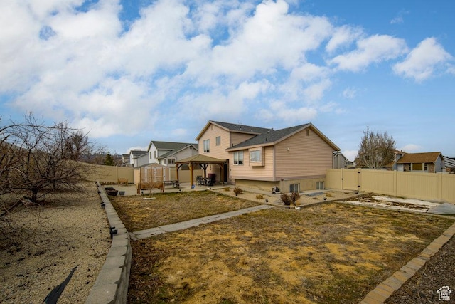 exterior space with a gazebo, a patio, a fenced backyard, and a gate