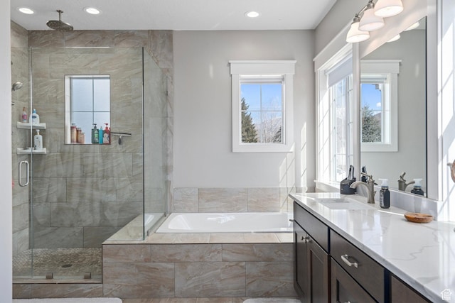 bathroom featuring a shower stall, a garden tub, vanity, and recessed lighting